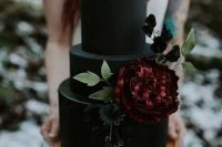 a black matte wedding cake decorated with sugar blooms and leaves is a stylish idea for Halloween