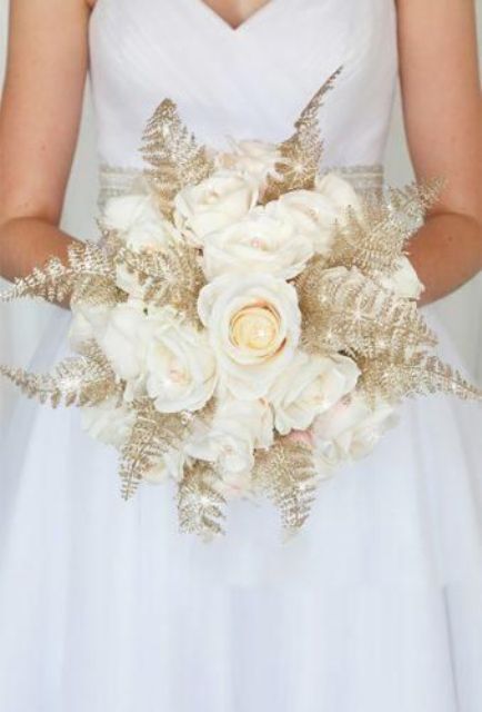 a bold wedding bouquet of white roses and gilded leaves is a lovely idea for a chic and glam wedding