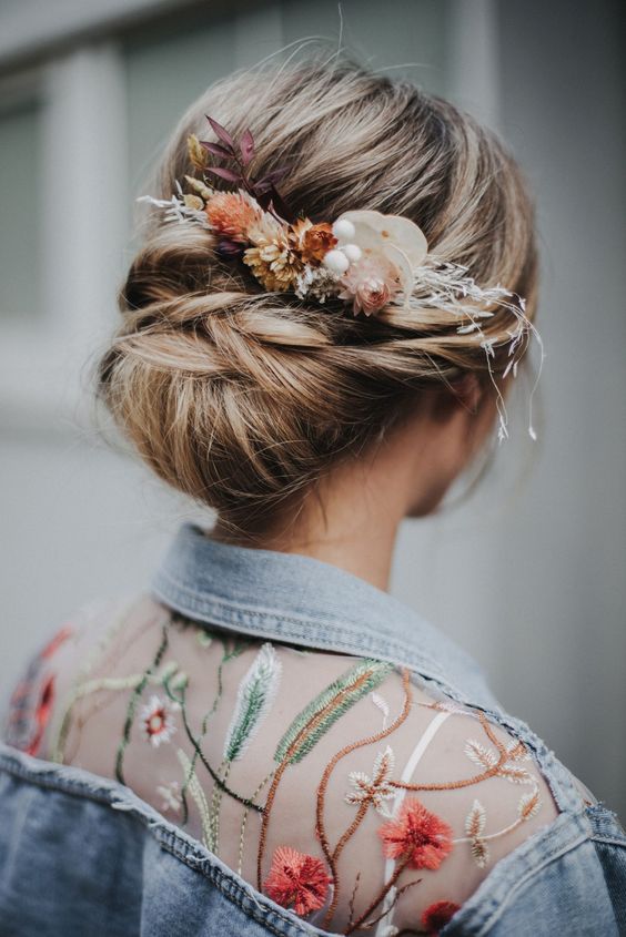a chic wedding updo with twists and a low bun, with dried hair and foliage is a lovely idea for a fall bridal look