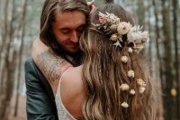 a creative fall boho wedding hairstyle with waves and braids, with dried flowers and leaves for an accent is amazing