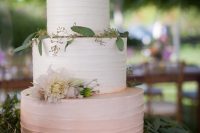 a delicate ombre pink wedding cake decorated with greenery and blush blooms is a lovely idea for a spring or summer wedding with a rustic feel