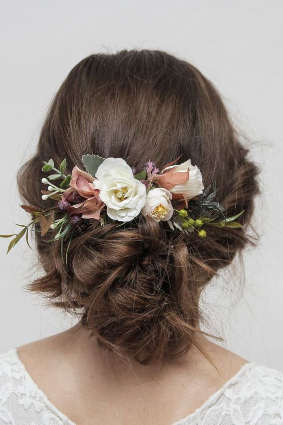 a delicate wedding updo witha bit of mess and waves, with neutral and dusty pink blooms and berries is a cool idea