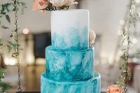 a fabulous turquoise watercolor and ombre wedding cake with gold touches, neutral and blush blooms on top and berries is a lovely idea for a summer wedding