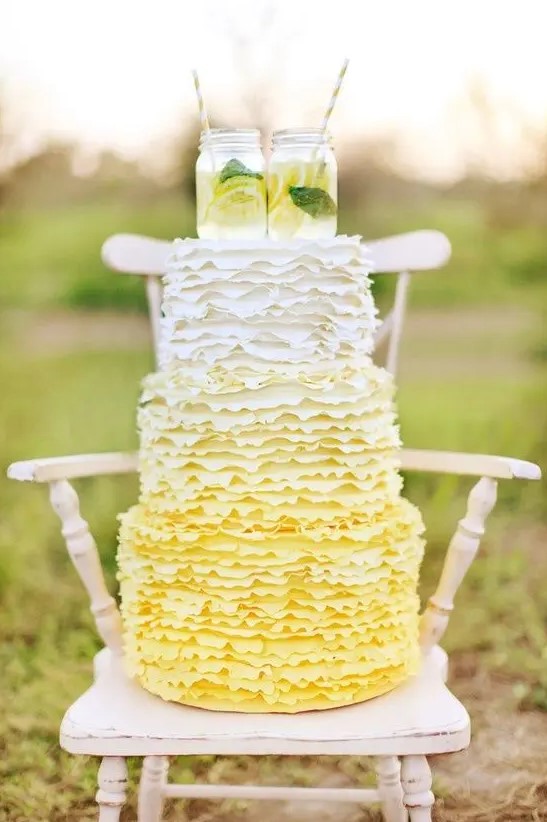 a fun ombre yellow ruffle wedding cake topped with mason jars with lemonade for a rustic wedding