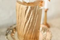 a gorgeous refined textural gold wedding cake topped with sugar flowers and leaves and beads, too