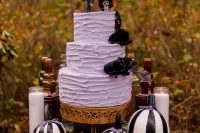 a lavender textural cake with black blooms and fun Sally and Jack Skellington toppers for a Halloween wedding