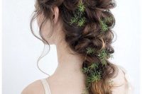 a loose messy twisted braid with greenery tucked in is a great solution for a fall woodland bride