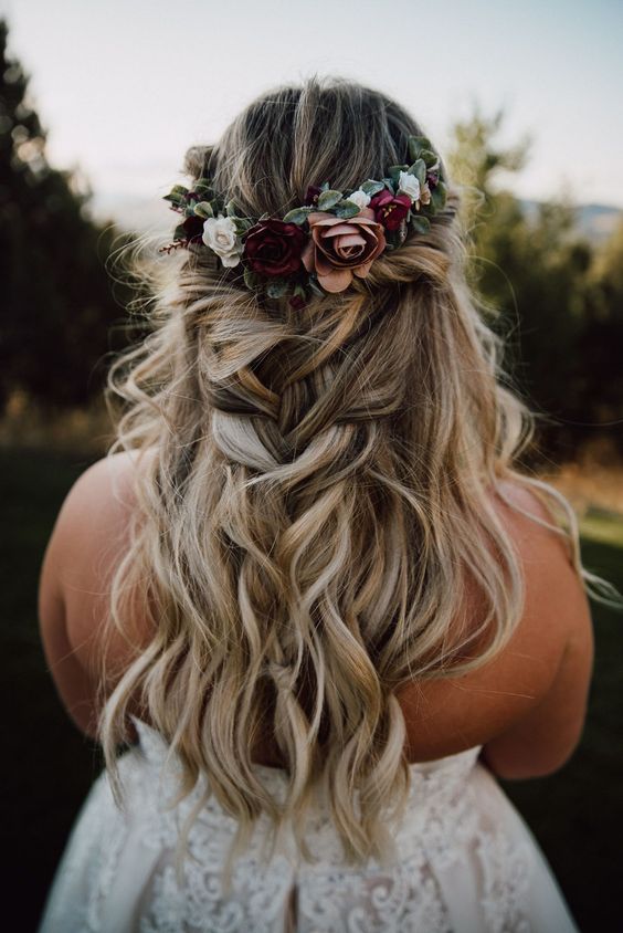 a lovely and classy half updo with a twisted halo and a loose braid and a bold fall flower crown is amazing