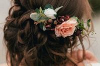 a low and messy updo with twists and braids, locks down and pink and burgundy blooms for an accent is amazing for the fall