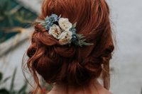 a messy low updo with twists and locks down with a bump on top and neutral and blue blooms and greenery