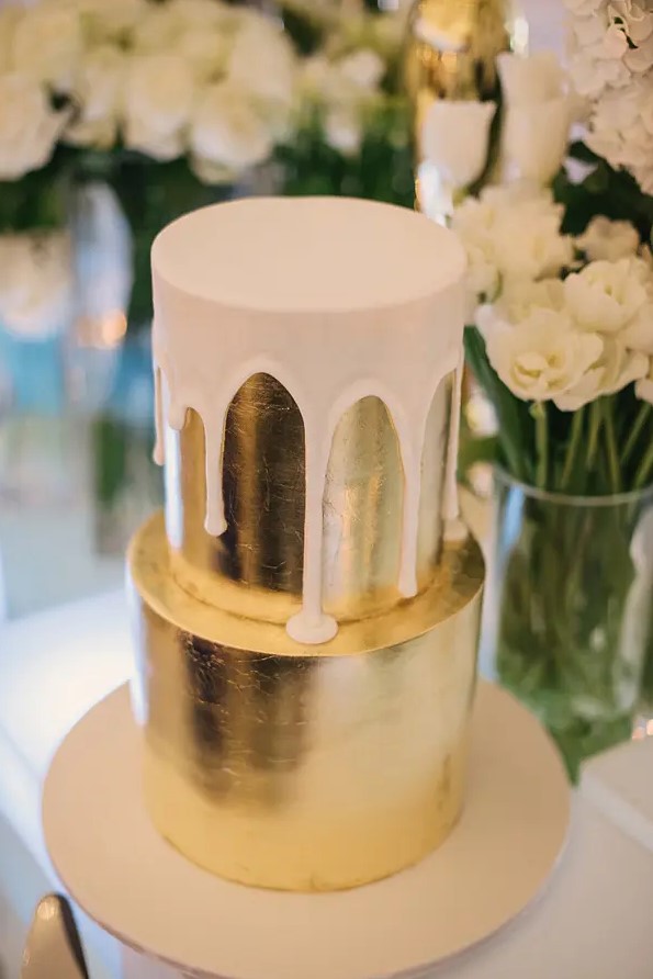 a sleek gold leaf wedding cake with creamy drip is a bold modern wedding dessert to rock