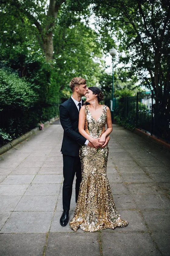 a sparkling gold wedding dress with a deep V-neckline and a train is a lovely idea for a glam wedding