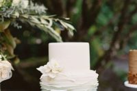 a stylish wedding cake with a white and on ombre green tier, with white sugar blooms is a delicate and chic idea for a spring or summer wedding
