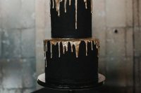 a super chic black wedding cake with gold drip is a very elegant and chic piece for a Halloween wedding