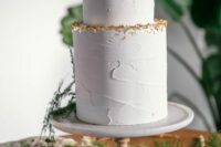 a textural white wedding cake with a bit of gold glitter on the edge is a chic and stylish idea for a refined modern wedding