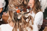 a wavy half updo with bright fresh and dried blooms and foliage is a lvoely idea for a fall boho bride