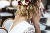 a wavy half updo with waves and braids, with a blush and burgundy flower headpiece is a gorgeous idea