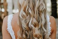 a wedding half updo with a braid and waves down, with bold blooms and blooming branches is a lovely idea for the fall