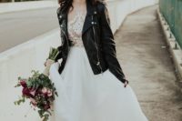 an edgy bridal look done with a black leather jacket and a dark lip plus a romantic wedding dress