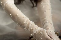 long sheer bridal gloves dotted with pearls look gorgeous and very delicate making a statement