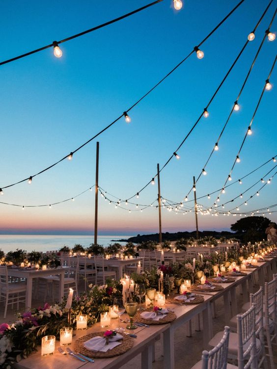 string lights paired with candles on the tables are amazing for destination weddings, and a lovely view is also amazing