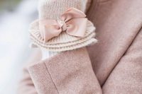 white knit gloves decorated with blush bows to match a blush coat and for a cute vintage feel