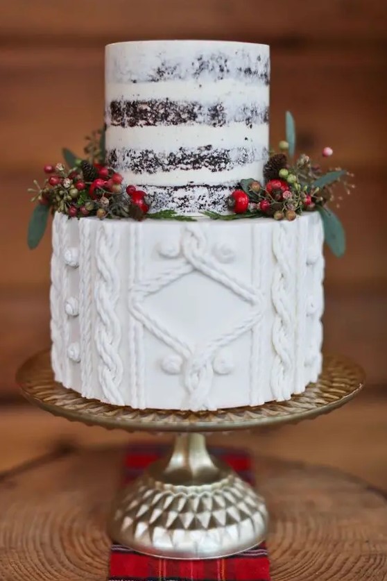 a Christmas wedding cake with a naked part and a cable knit one plus berries and little pinecones around