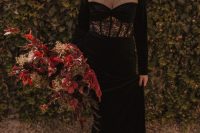 a black velvet wedding dress with an illusion neckline and a lace insert, statement earrings and a chic updo