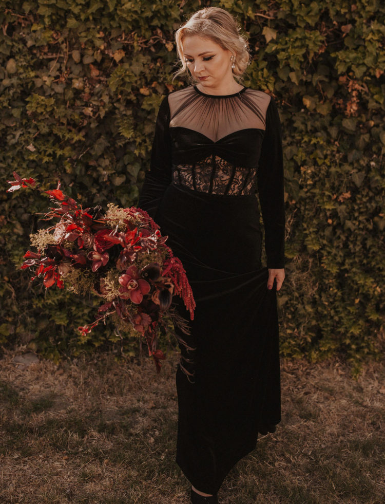 a black velvet wedding dress with an illusion neckline and a lace insert, statement earrings and a chic updo