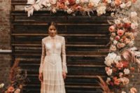 a boho rustic wedding backdrop mad eof stained reclaimed wood,pink, rust, white blooms, painted grasses and large foliage