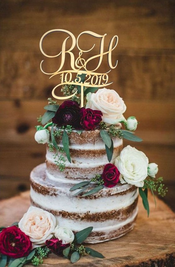 a bold naked wedding cake with neutral and burgundy blooms, with greenery and a calligraphy topper for a summer wedding