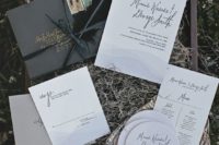 a box wit hay, modern wedding invitation suite, a black envelope, a large feather, elegant calligraphy