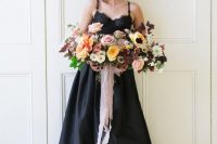 a chic black spaghetti strap wedding dress with a lace bodice and a high low skirt looks very modern and romantic
