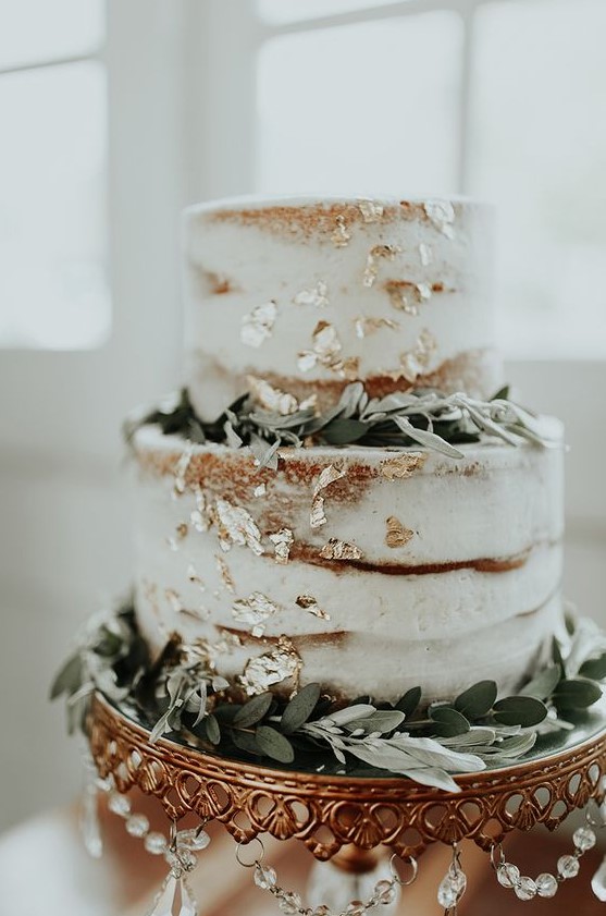 a chic naked wedding cake with gold leaf and greenery for a cute rustic or modern wedding
