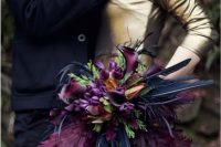 a colorful Halloween bouquet with purple blooms, purple and black feathers and some greenery