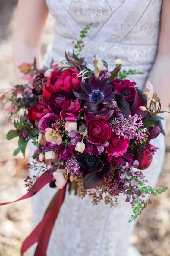 a colorful Halloween wedding bouquet with pink, hot pink and purple blooms and some greenery will stand out with a black dress