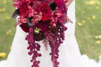a colorful Halloween wedding bouquet with red, pink and hot pink blooms, deep purple blooms and cascading lisianthus