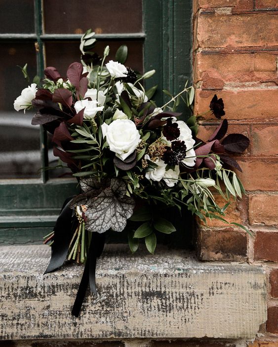 a contrasting wedding bouquet with white and dark purple blooms, dark foliage and greenery and much texture for Halloween