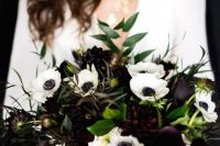 a contrasting wedding bouquet with white and deep purple blooms and greenery is stylish and cool