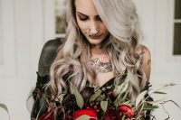 a dark Halloween wedding bouquet with black and red blooms and much greenery is stylish and bold