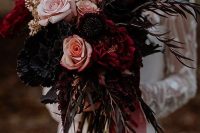 a dark wedding bouquet of dark, burgundy and blush blooms, dark foliage and some glittered touches