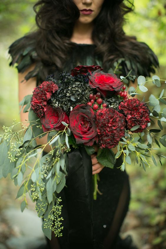 a dark wedding bouquet with black hydrangeas, red roses, berries and eucalyptus for a Halloween bride