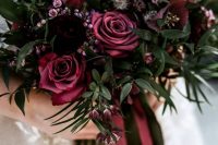 a deep purple and burgundy wedding bouquet with some greenery is an elegant monochromatic piece for a Halloween bride