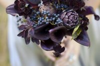 a deep purple wedding bouquet with artichokes, privet berries, dark foliage is super stylish
