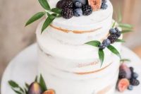 a delicate and pretty fall vineyard wedding cake – a semi-naked piece topped with fresh greenery, figs, blackberries and blueberries