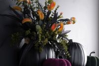 a fantastic Halloween wedding centerpiece of black and purple pumpkins, black leaves and bold blooms is a gorgeous idea