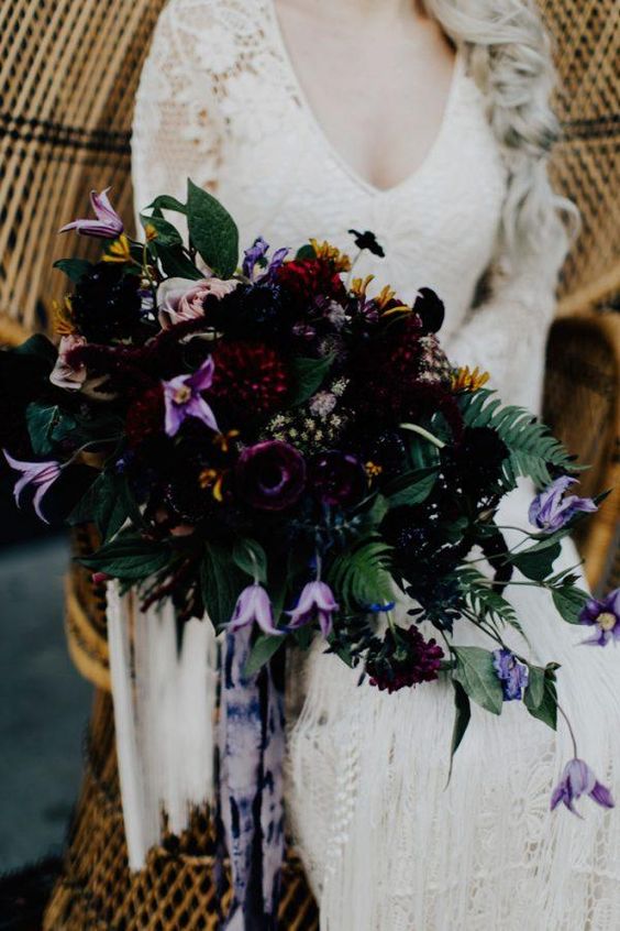 a gorgeous dark wedding bouquet with deep purple, burgundy and purple blooms, foliage and tie dye ribbons for a Halloween bride