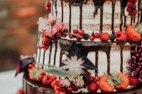 a gorgeous naked wedding cake with chocolate drip, fresh berries and blooms is a fantastic idea for a boho or rustic wedding in the fall
