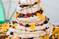 a gorgeous pavlova wedding cake with lots of fresh fruit, berris and bright petals is a very bold and delicious idea