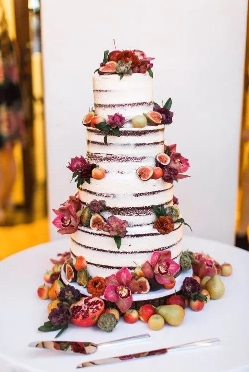 a lovely four tier naked wedding cake with bold blooms, fruits and berries will be a nice idea for a fall wedding with a farmhouse or other theme